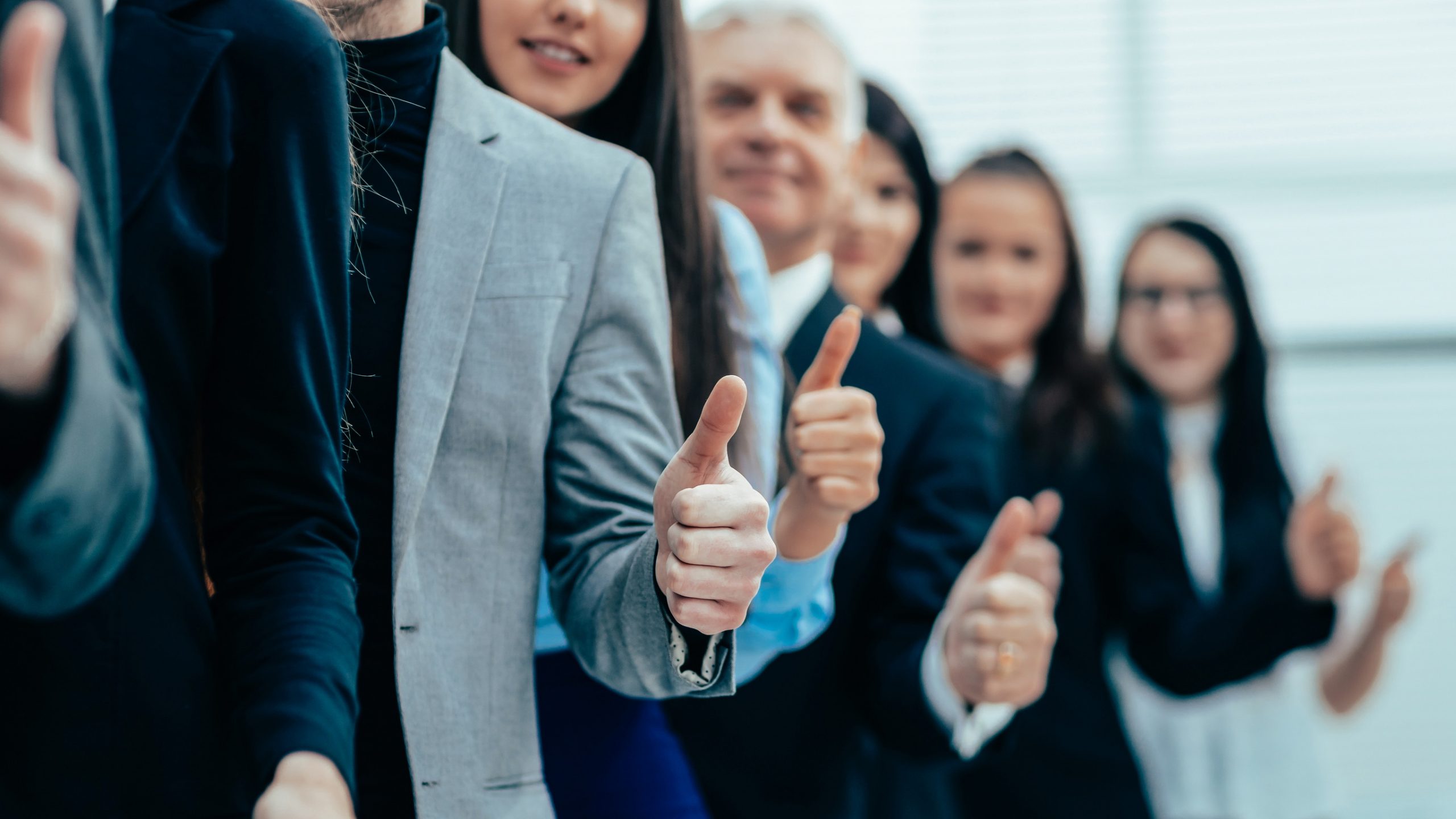 group of young entrepreneurs standing together and giving a thu