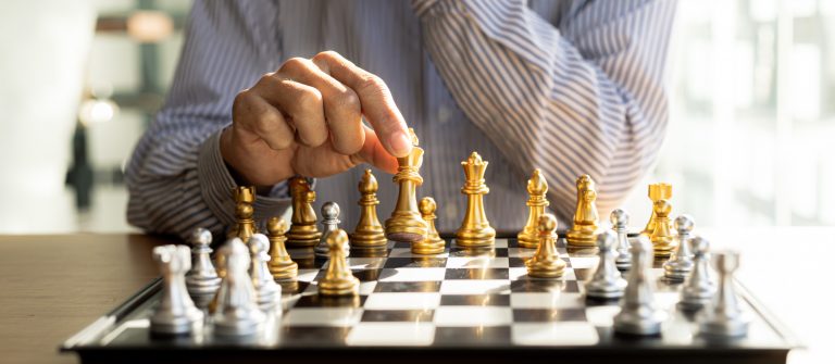 Person playing chess board game, business man concept image hold